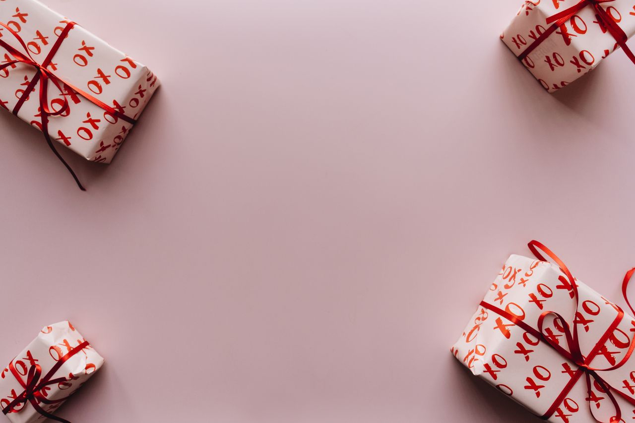 Celebrate with wrapped gifts featuring red ribbons and XO pattern.